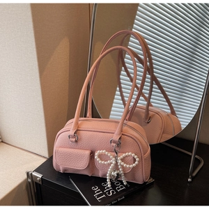 Detail of pink lychee leather handbag with decorative pearl bow and double pockets