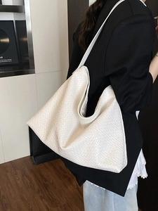 Minimalist white woven leather tote bag shown on model with spacious shoulder carry design