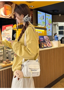 Détail du sac bandoulière blanc oreilles de chat avec peluche et sangle