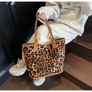Leopard print canvas tote bag carried by model on stairs, spacious fashion shoulder bag