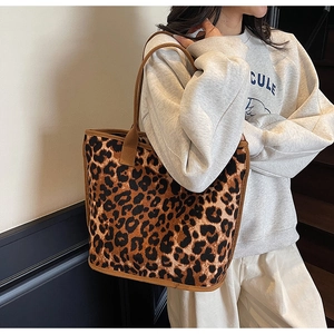 Leopard print tote bag with brown contrast straps shown in a lifestyle model shot