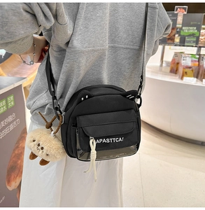 Détail du sac chat en toile noire avec poche transparente et pendentif en peluche