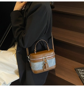 Détail du sac boîte vintage en cuir marron et denim gris avec coutures contrastées
