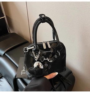 Détails de sac noir brillant en forme de coquillage avec chaîne et pendentif coeur
