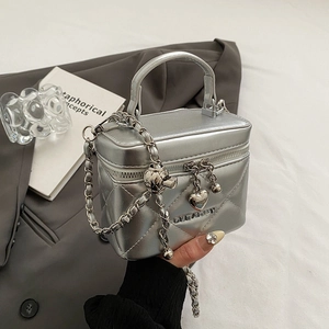 Macro detail of silver quilted mini bag with metallic texture and chain strap