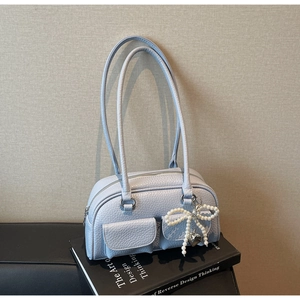 Detail of light blue lychee pattern leather bag with pearl bow and heart charm