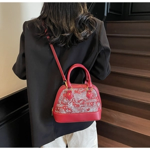Detailed embroidery of phoenix and clouds on a red leather shell bag for women