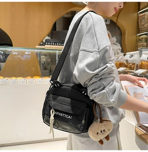 Détail du sac bandoulière noir en toile avec oreilles de chat et charme en peluche