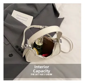Interior capacity detail of a cream crescent bag showing phone and makeup storage