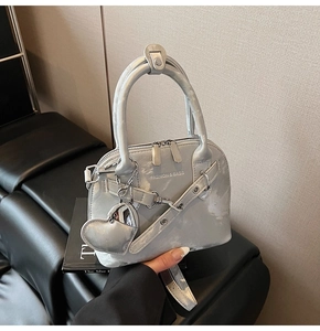 Détail du sac à main argenté métallisé avec breloque cœur et lettrage Fashion & Bags