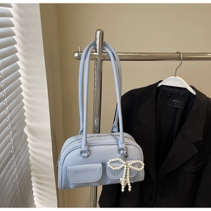 Detail of light blue lychee texture handbag with pearl bow charm on silver hanger