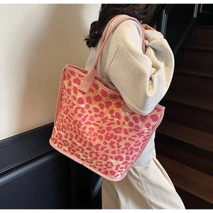 Detailed view of pink leopard print tote bag fabric and texture on model shoulder