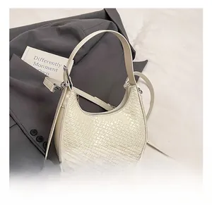 Detail of white embossed hobo bag with crocodile texture and silver hardware