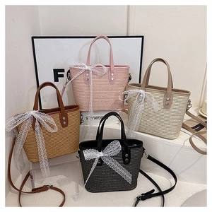 Detail view of woven bucket bags featuring large lace bows in pink, beige, brown, and black