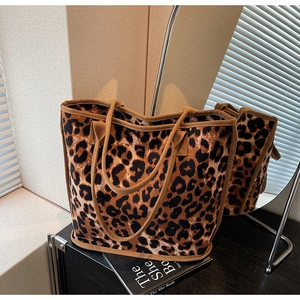 Detail of leopard print tote bag with reinforced edges and woven handles on a vanity desk