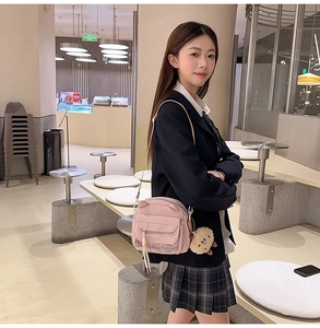Détail du sac bandoulière rose avec oreilles de chat, poche transparente et pompon chat