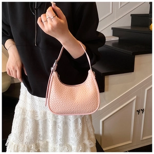 Detail of pink crescent bag showing woven texture and sleek minimalist shoulder strap design