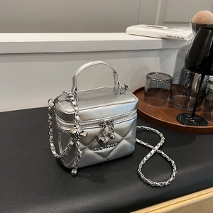 Detailed view of silver quilted chain bag with heart charm and metallic finish
