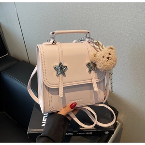 Pink mini crossbody bag featuring silver star hardware and a cute teddy bear charm