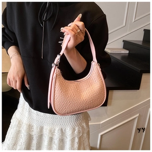 Detail of pink embossed faux leather shoulder bag featuring a unique crescent shape