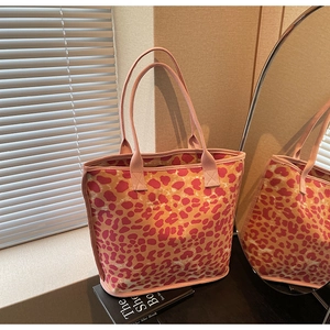 Detail of pink and orange leopard print canvas tote bag with reinforced handles and large capacity