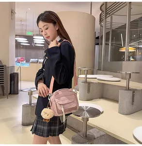 Détail du sac bandoulière rose avec poche avant transparente et ours en peluche