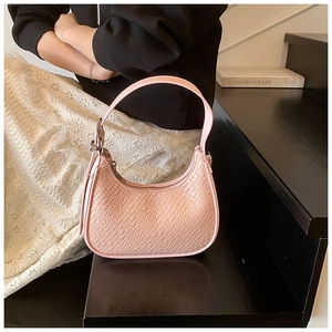 Close-up of pink crocodile texture on a crescent hobo shoulder bag with metal zipper