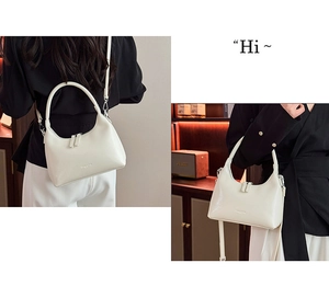 Detail showing the white crescent underarm bag with double zipper and smooth leather texture