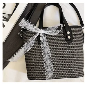Detail of hand-woven bucket bag featuring a large white lace bow and leather handle