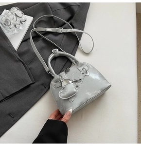 Mini sac coquillage argenté avec inscription fashion et breloque cœur sur blazer gris
