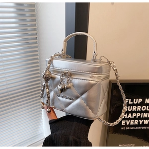 Detail of silver quilted trunk bag with metallic CALEAVOK logo and chain strap