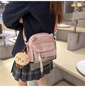 Sac bandoulière en toile rose avec oreilles de chat et porte-clés peluche sur modèle
