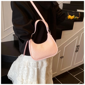 Detailed view of pink leather crescent bag with woven texture and adjustable strap