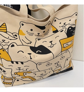 Close-up of cute cartoon cat prints and high-quality canvas texture on a large tote bag