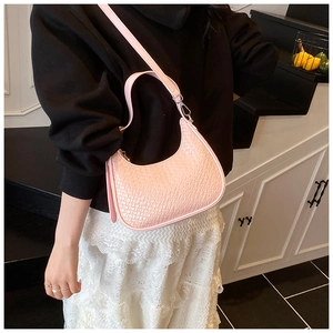 Detail of pink woven crescent bag showing textured synthetic leather and silver zipper