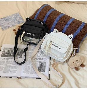 Détail de sacs à bandoulière chat noir et blanc avec fenêtre PVC et charm en peluche