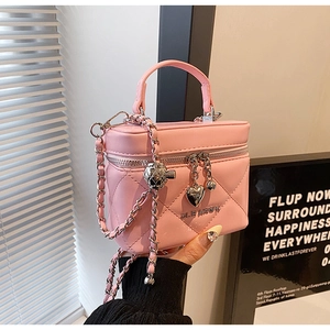 Detail of pink quilted mini vanity bag with heart pendant and silver chain strap