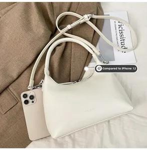 Detailed comparison of the off-white hobo bag size next to an iPhone 12 phone