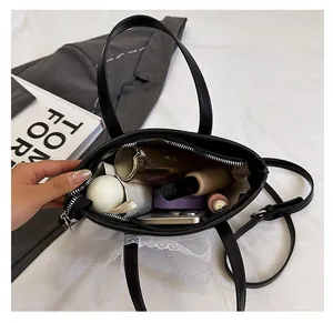 Internal view of spacious black woven handbag with cosmetics and smartphone stored inside