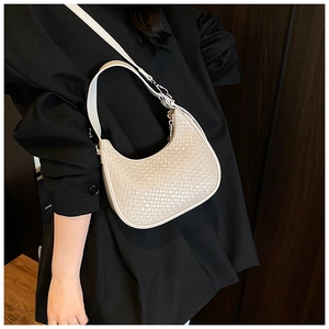 Detail of off-white woven hobo bag showing fine checkerboard texture and silver zipper