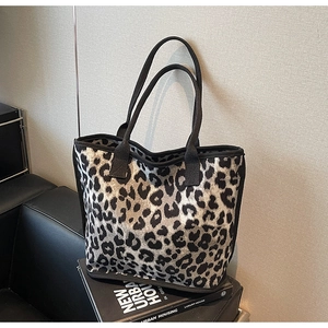 Close-up of leopard print tote bag with black handles on a modern interior setting