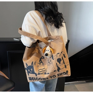 Detailed side view of large canvas tote bag with cartoon print and plush dog charm