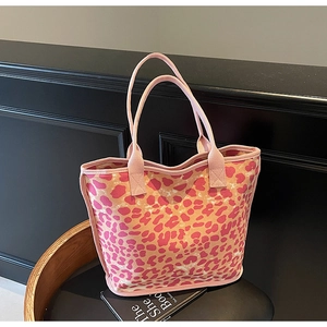 Detail of pink and orange leopard print canvas tote bag with woven handles