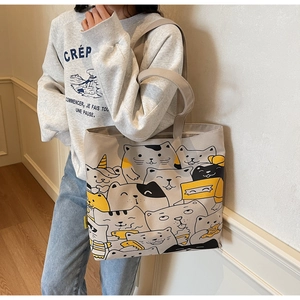Detailed view of large canvas tote bag featuring playful all-over cartoon cat print