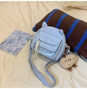 Détail du sac à bandoulière bleu clair avec oreilles de chat et breloque en peluche