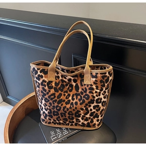 Close-up of leopard print canvas tote bag with brown webbing handle and fabric texture