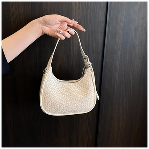 Detail of cream woven hobo bag showing intricate texture and silver zipper closure
