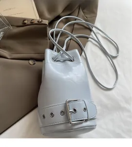 Détail du sac seau bleu clair avec boucle argentée décorative et fine bandoulière à cordon