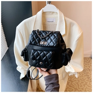 Close-up of black quilted leather backpack with metal chain and turn-lock detail
