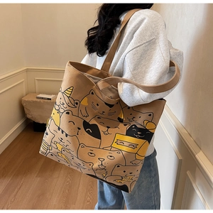 Close-up of canvas tote bag featuring cute cartoon cat patterns and durable shoulder straps